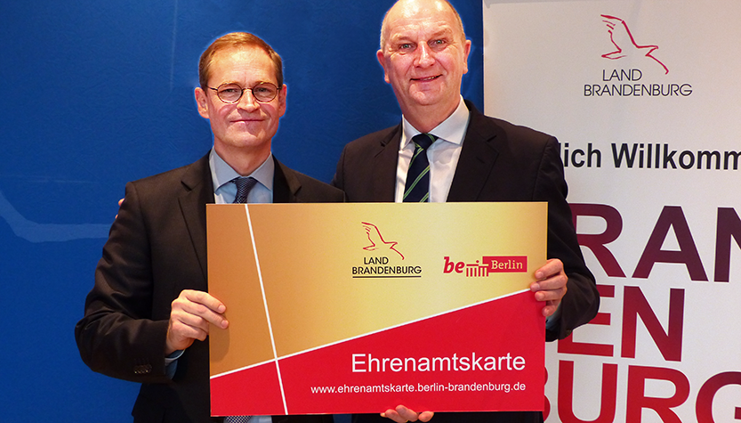 Michael Müller und Dietmar Woidke mit der neuen Ehrenamtskarte (Foto: brandenburg.de)